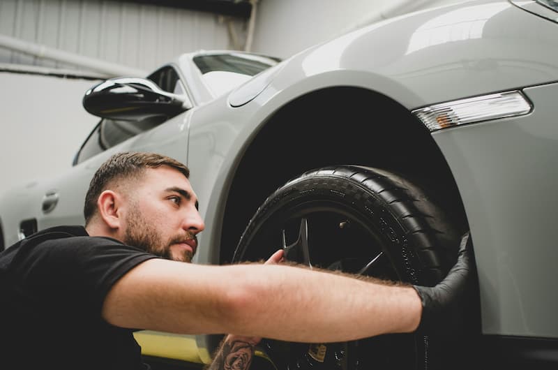 laver sa voiture, homme qui lave sa voiture à la main